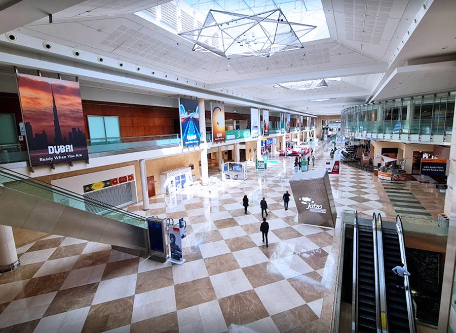 Spacious interior of Dubai World Trade Centre with escalators and banners.