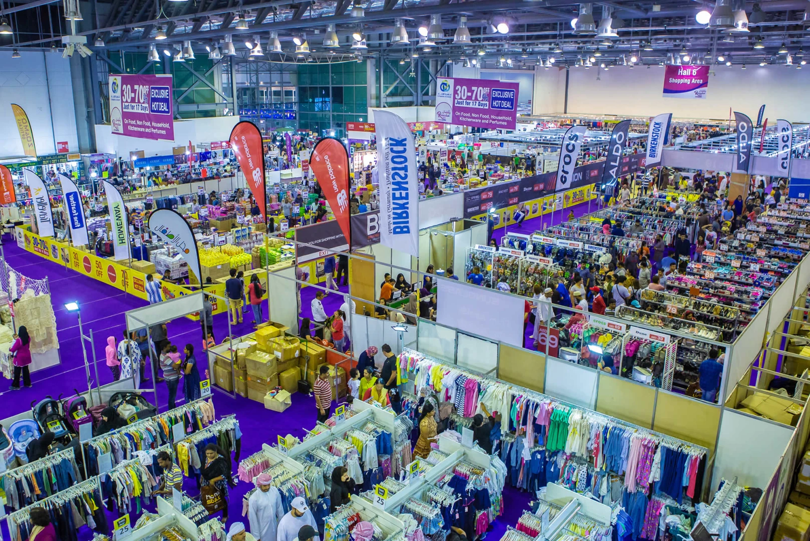 Busy trade fair at Expo Centre Sharjah with colorful booths and banners.