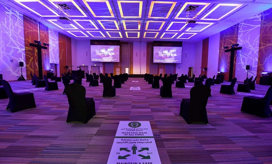 Spacious conference hall at ADNEC Centre Abu Dhabi with distanced seating.