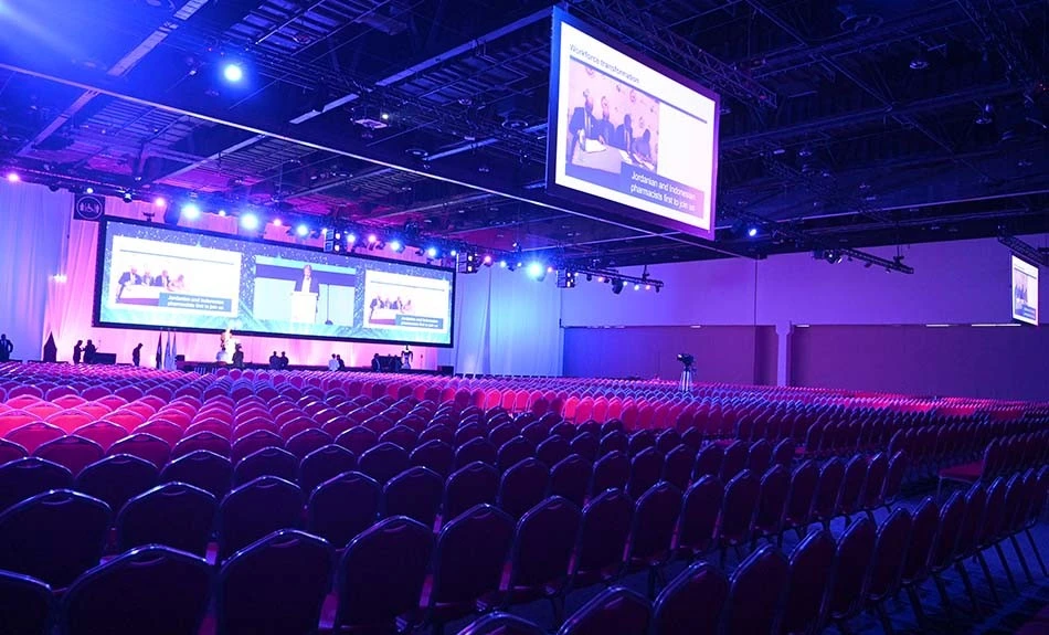 ADNEC Centre Abu Dhabi auditorium with rows of red chairs.
