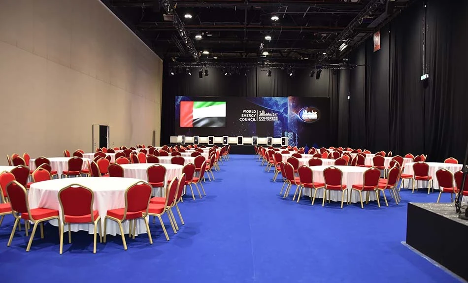 ADNEC Centre Abu Dhabi event hall with round tables and chairs.