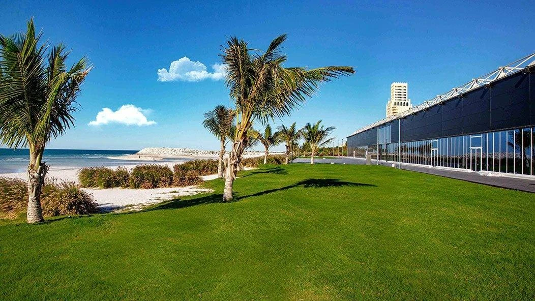 Al Hamra Exhibition Center, Ras Al-Khaimah, beachfront with palm trees.