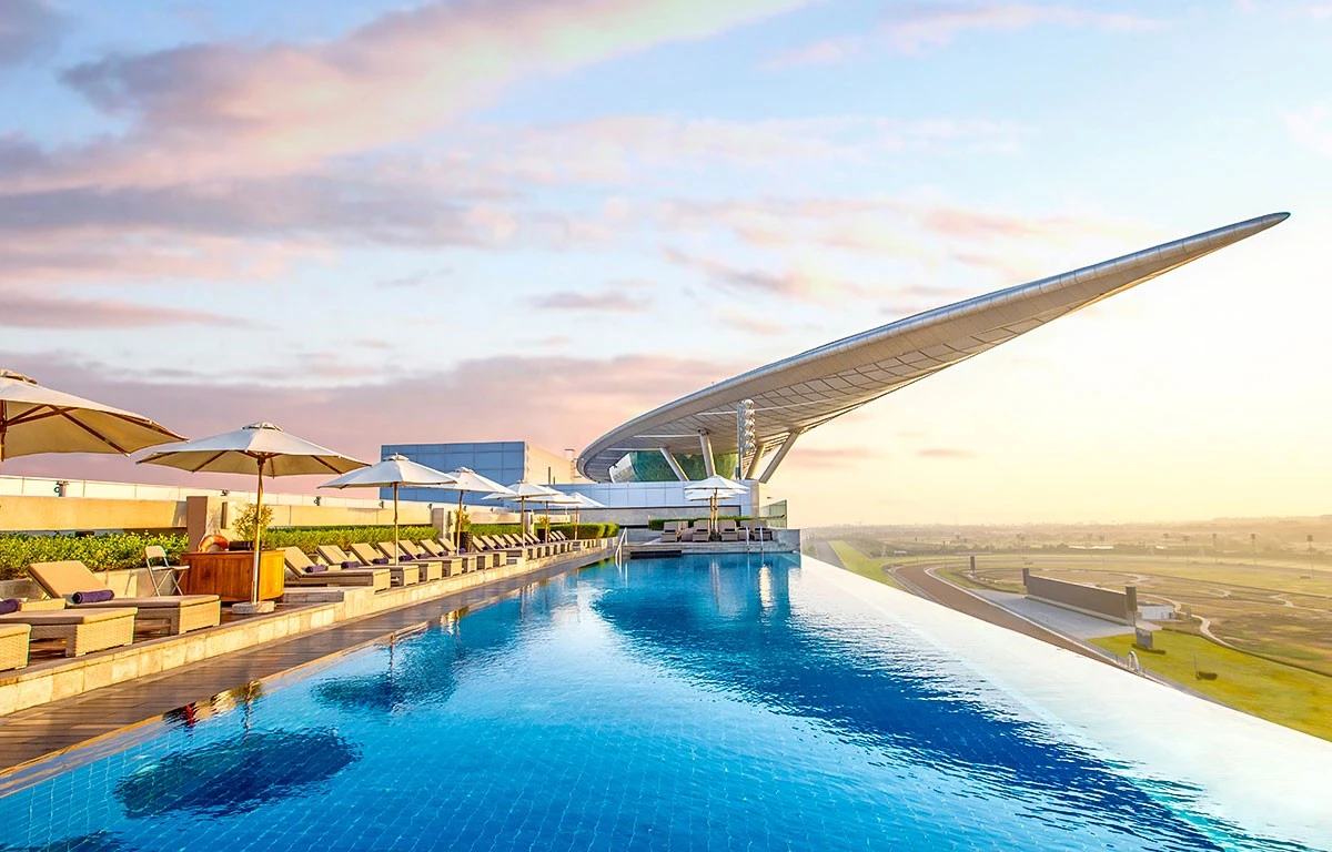 Infinity pool at The Meydan Hotel, Dubai, with sunset view.
