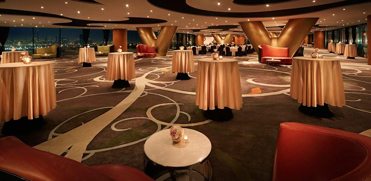 Elegant event space at The Meydan Hotel, Dubai, with round tables.