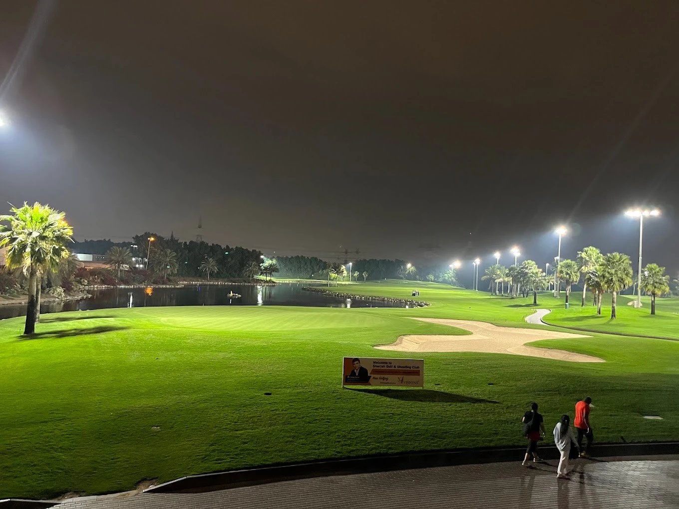 Night view of Sharjah Golf and Shooting Club's illuminated golf course.
