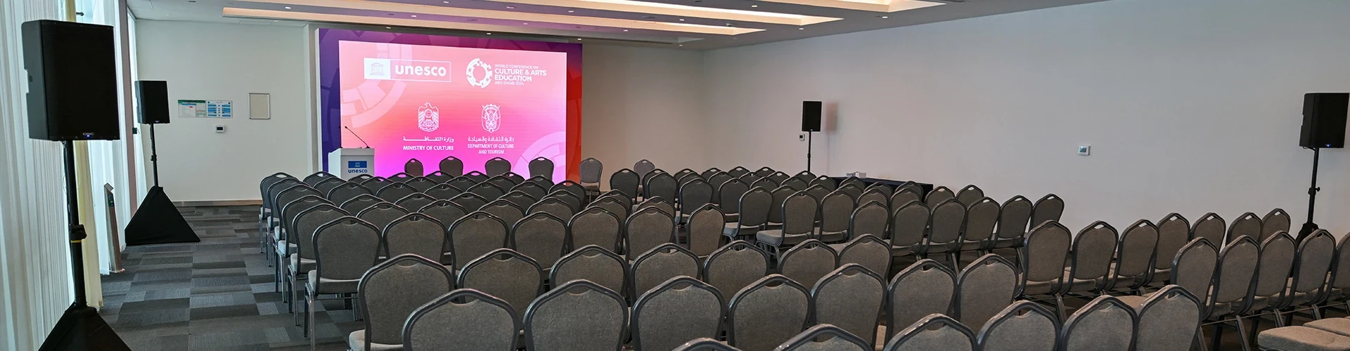 Conference room at ADNEC Centre Abu Dhabi with chairs and stage.