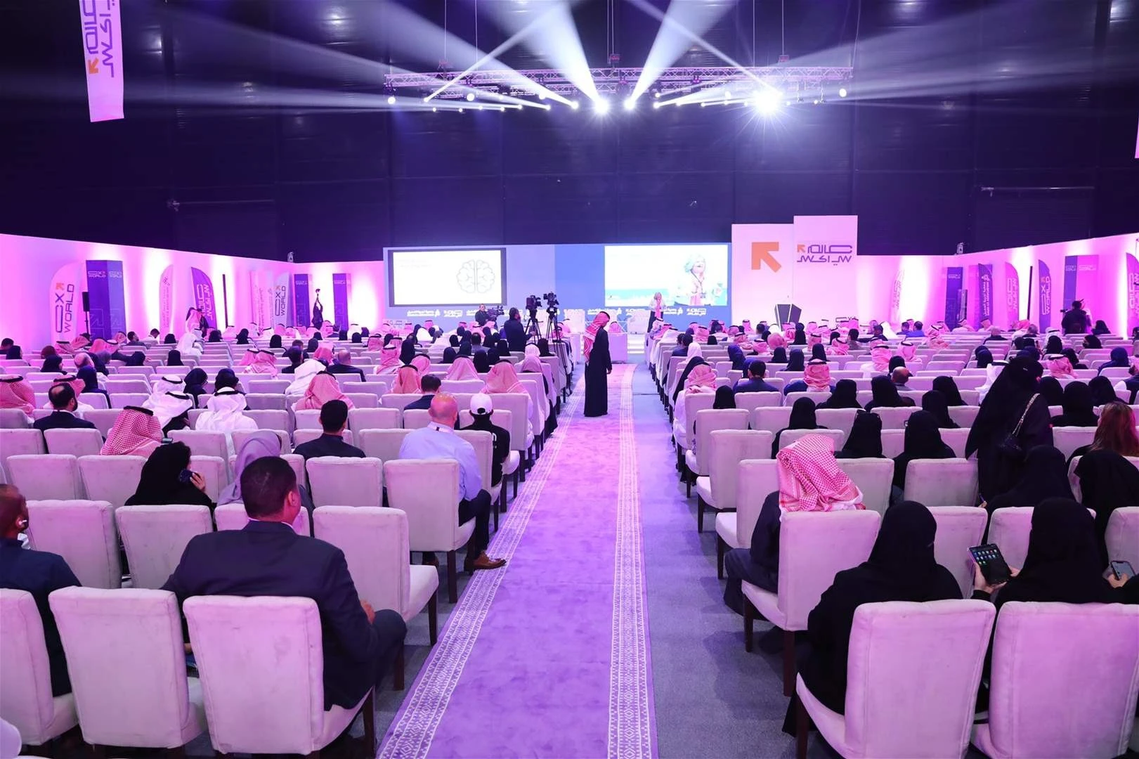 Conference at The Arena Riyadh Venue, attendees seated facing stage.