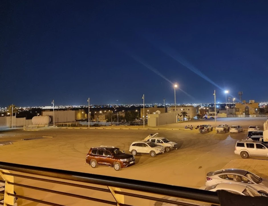Night view of Riyadh International Convention Center parking lot, city lights visible.